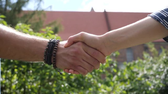 Handshake of man and woman during meeting outdoors in city