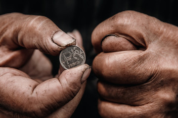 Fototapeta na wymiar Concept Pension of Russia. Dirty hands old man poor with coin ruble.