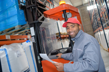 forklift is putting cargo from warehouse to truck outdoors