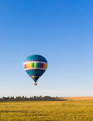 Fototapeta premium Colorful hot-air balloon flying over the forest