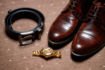 classic brown shoes . clock and belt on wooden floor. vintage picture