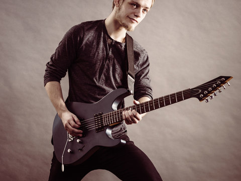 Young man playing electric guitar