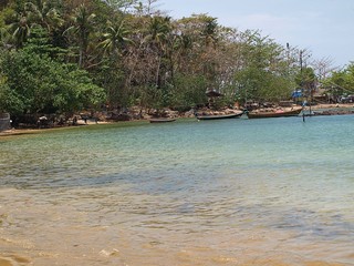 fishing boats moored at the waters edge on the tropical Island of  Koh-Lanta Thailand