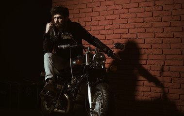 repair shop. bearded man biker in repair shop. repair shop or biker club. repair shop garage. bike is his life.