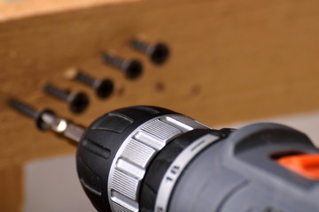  screwdriver on a wooden background screwed with screws