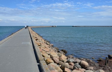 Obraz premium Touristen auf der Mole in der Ostsee am Fährhafen Puttgarden auf der Insel Fehmarn 