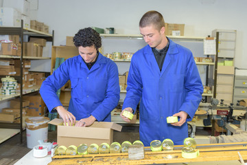 Factory workers packing tins into box