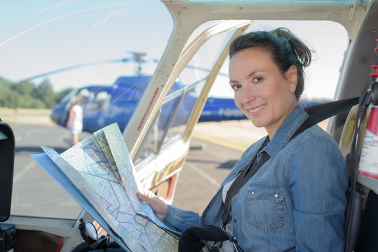 woman holding a map in the helicopter cockpit