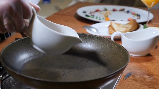 Food preparation. Chef pours cane sugar on pan to prepare caramel sauce. Slow motion
