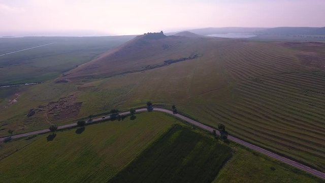 Drone Aerial Flying Towards Large Romanian Hill with Vast Summer Landscape