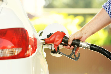 Refueling car at the refuel station on a sun sunlight background