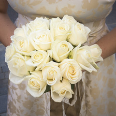 Wedding white bouquet of roses in the hands of the bride