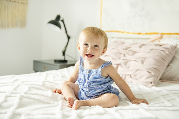 Cute baby girl on bed at home