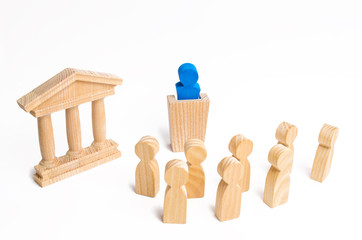 The leader from the rostrum speaks a speech addressing a crowd of people. Business concept of leader and leadership qualities, crowd management, political debate and elections. Business management.