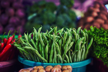 Bright summer background. Green beans in farmer market. Healthy vegetable vegetarian, organic food, raw ingredient. Natural nutrition for diet. Organic vegetables. Summer crops. Selective focus.
