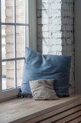 a pair of pillows on the windowsill