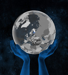 Finland on globe in hands in space