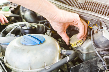 The mechanic's hands performing a car engine check