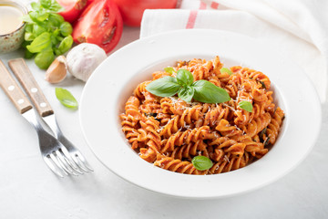 Fusilli pasta with tomato sauce, garlic, Basil and Parmesan cheese on white background