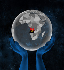 Angola on globe in hands in space