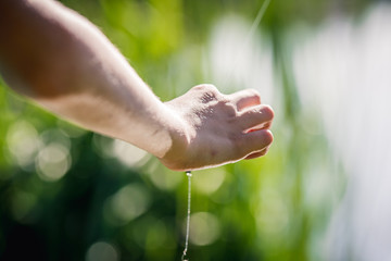 The hand keeps the line from the fishing rod