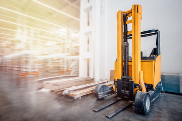 Fototapeta na wymiar Warehouse industrial premises for storing materials and wood, there is forklift containers. Concept logistics, transport. Motion blur effect. Bright sunlight.