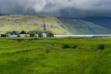 Small Fishermen Houses surrounded by a fjord in Hósvík, Faroe Islands