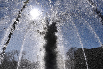 A closeup of a fountain with the sun directly behind it.
