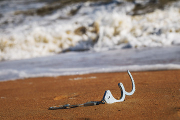 Concept of freedom: open handcuffs on sand lying on a sandy beach near the sea