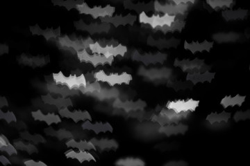 holidays, decoration and party concept - defocused white bats silhouette ghosts on black for...