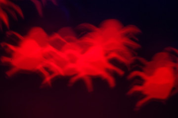 holidays, decoration and party concept - defocused bokeh lights red spiders silhouette on black for halloween background