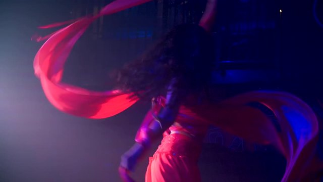 Slow motion latin dancer twirling while performing a beautiful scarf dance