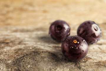 Fresh acai berries on wooden table, closeup