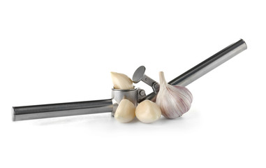 Garlic press and cloves on white background. Kitchen utensil