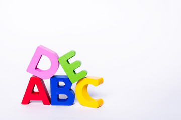 ABCDE letters in different colors on an isolated white background. Wooden, colorful, children's letters. The concept of learning to read and write.