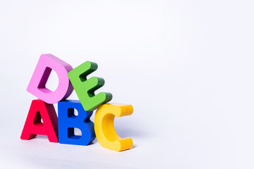 ABCDE letters in different colors on an isolated white background. Wooden, colorful, children's...