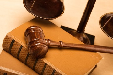 Closeup of Gavel on Books with Scale on Background