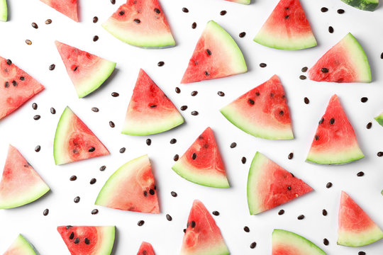 Flat lay composition with slices and seeds of watermelon on white background