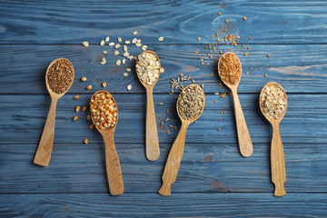 Flat lay composition with different types of grains and cereals on wooden background