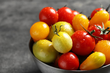 Bowl with tasty juicy tomatoes on table, closeup