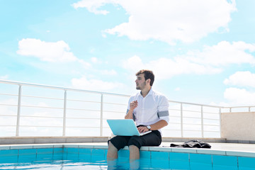 working on laptop at the pool, work on holiday concept