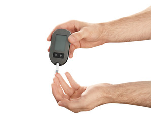 Man checking blood sugar level with glucometer on white background. Diabetes test