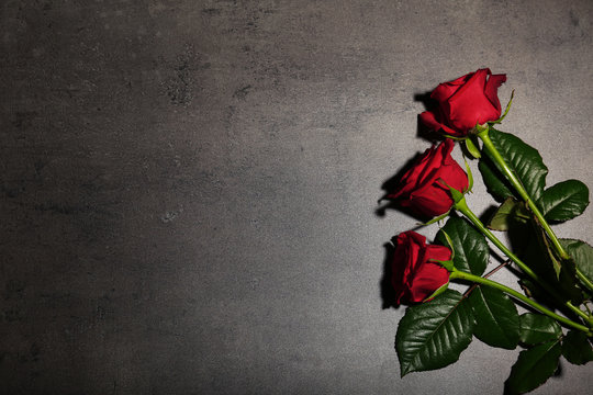 Fototapeta Beautiful red roses on grey background, top view. Funeral symbol