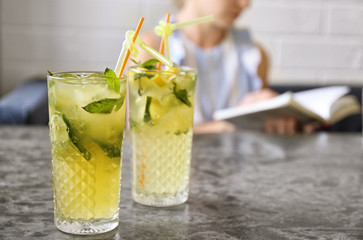 Glasses of iced lemonade on table indoors