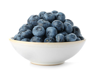 Bowl full of fresh ripe blueberries on white background
