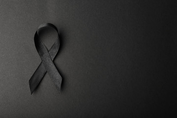 Black ribbon and space for text on dark background, top view. Funeral accessory - obrazy, fototapety, plakaty