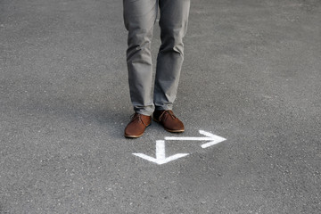 Man standing near arrows on asphalt. Choice concept © New Africa