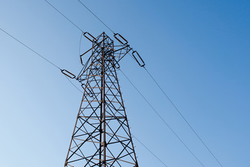 Energy pole. High voltage pole on a clean blue background. Electricity pole connecting two places.
