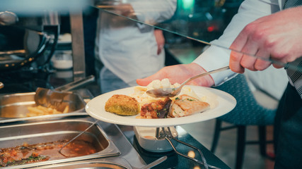 Obraz na płótnie Canvas buffet: people take food in plates.