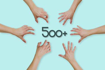 Top view of hands reaching for the social program in Poland 500+. People are throwing themselves in 500+ funding for families with children. Concept of country help, country problems.